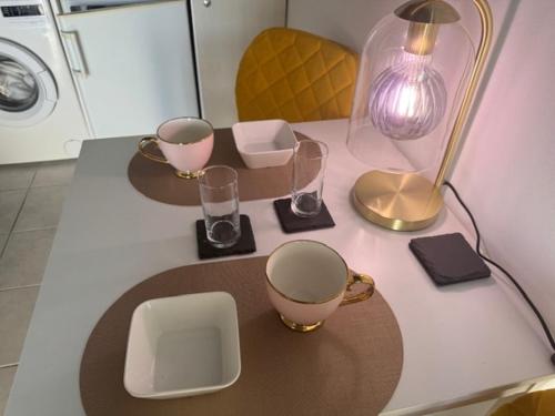 a table with a lamp and glasses on it at Cozy Studio in Cannes in Le Cannet