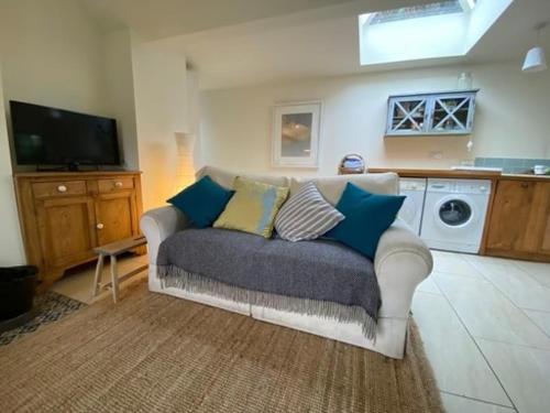 un salon avec un canapé et une machine à laver dans l'établissement Seaside Cottage Kinsale, à Feevaghmore