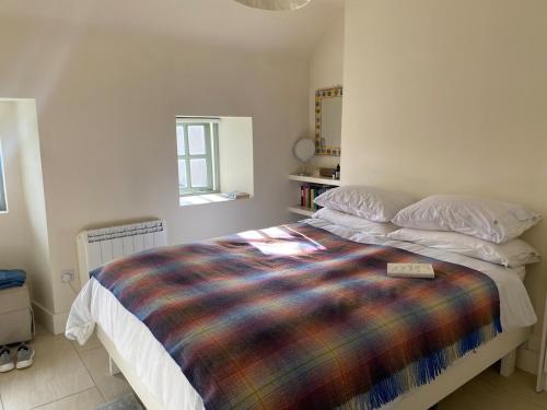- une chambre avec un lit et une couverture colorée dans l'établissement Seaside Cottage Kinsale, à Feevaghmore