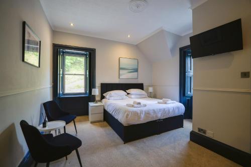 a bedroom with a bed and a table and chairs at Dalrigh House in Oban