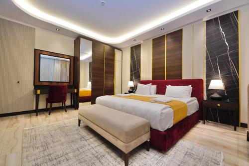 a bedroom with a large bed with a red headboard at Al- Abasly Suites in Baghdād