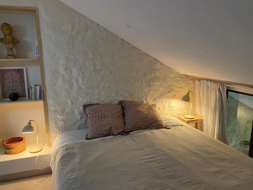 a bed with two pillows on it in a bedroom at Chambres d'hôtes -L'Atelier du Presbytère 