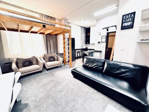 a living room with a couch and a loft bed at The All-in-One Loft in Ulaanbaatar