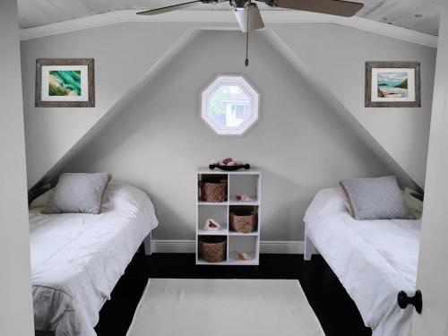 Zimmer im Dachgeschoss mit 2 Betten und einem Fenster in der Unterkunft Canal Front 3 bedroom 2 bathroom in Nassau