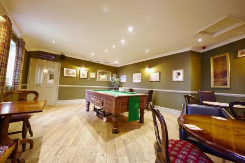 a gaming room with a pool table and chairs at The Dog and Partridge in Langsett
