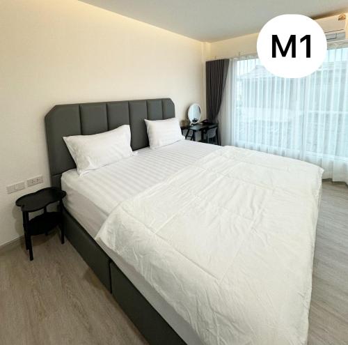 a bedroom with a large bed with white sheets at Monday Guesthouse2 Hatyai in Hat Yai