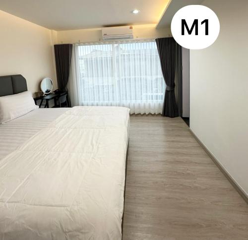 a bedroom with a large white bed and a window at Monday Guesthouse2 Hatyai in Hat Yai