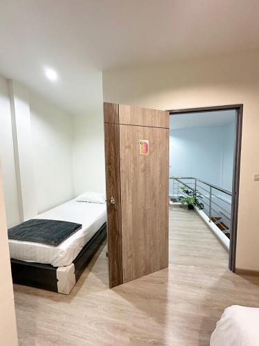 a bedroom with a bed and a door with a balcony at Monday Guesthouse2 Hatyai in Hat Yai