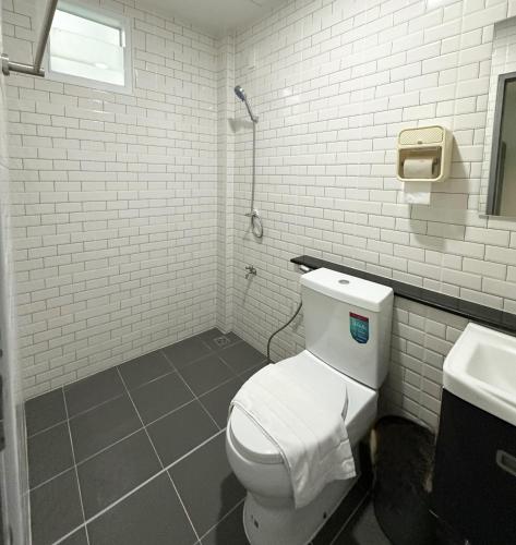 a bathroom with a white toilet and a sink at Monday Guesthouse2 Hatyai in Hat Yai