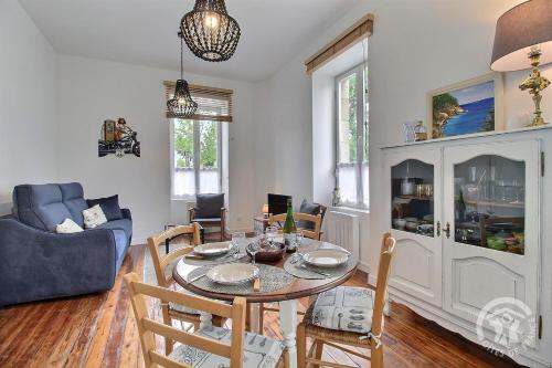a living room with a table and chairs and a couch at Chez sylvie in Paimpol