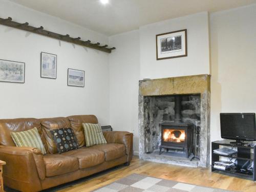 a living room with a couch and a fireplace at Kildale Barn in Kildale