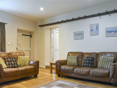 a living room with two brown leather couches at Kildale Barn in Kildale