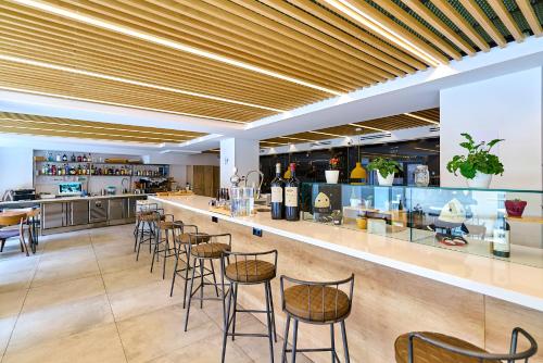 a bar in a restaurant with chairs and a counter at Hotel Melibea by gaiarooms in Salamanca
