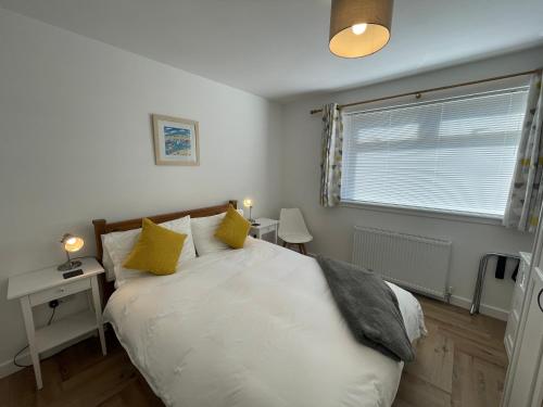 een slaapkamer met een groot wit bed met gele kussens bij Nº Twenty Spottiswoode in St Andrews