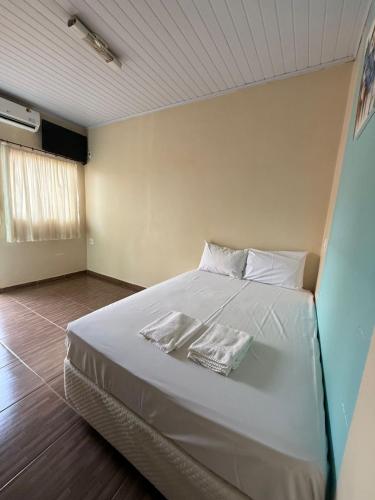 a bedroom with a bed with two towels on it at Pousada cores in Olímpia