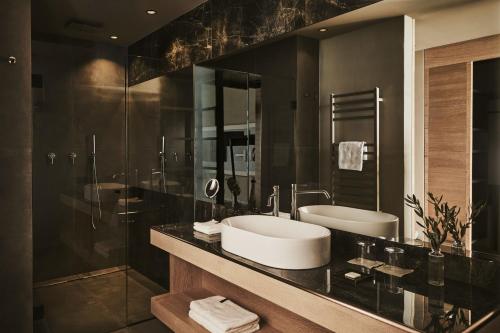 a bathroom with two sinks and a glass shower at Cape of Senses in Torri del Benaco