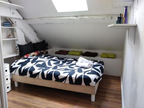 a bedroom with a bed with a black and white comforter at Les 4c-calm-central-close to Prenois circuit in Velars-sur-Ouche