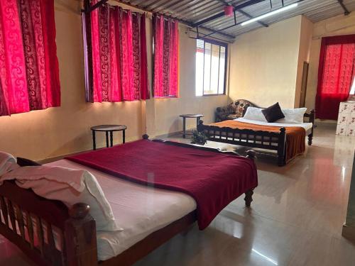 - une chambre avec 2 lits et des rideaux rouges dans l'établissement Coorg Heaven Homestay, à Madikeri