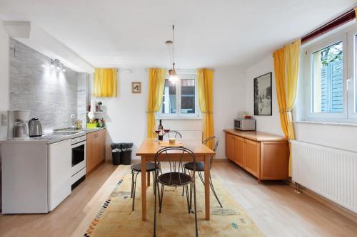 a kitchen with a table and a kitchen with yellow curtains at Haus am Apfelbaum in Bad Säckingen