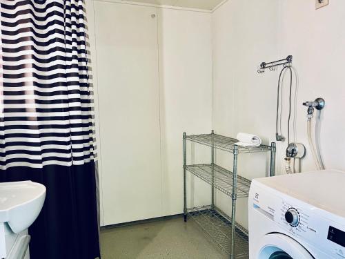 a bathroom with a sink and a washing machine at Kotimaailma Pori Väinölä Latokartanontie 16-18 in Pori