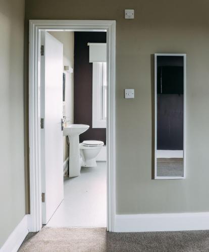 a bathroom with a toilet and a mirror at Station Hotel in Hucknall