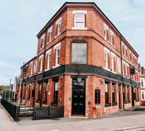 a red brick building with a black door on a street at Station Hotel in Hucknall