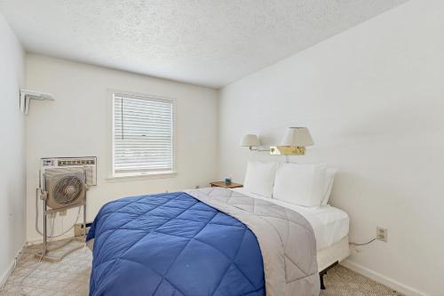 Un dormitorio con una cama azul y una ventana. en Birch Tree Lane - Unit 314, en Bar Harbor