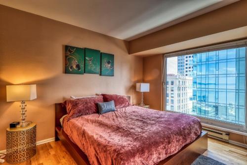 een slaapkamer met een groot bed en een groot raam bij Newmark Tower Seattle Suite in Seattle