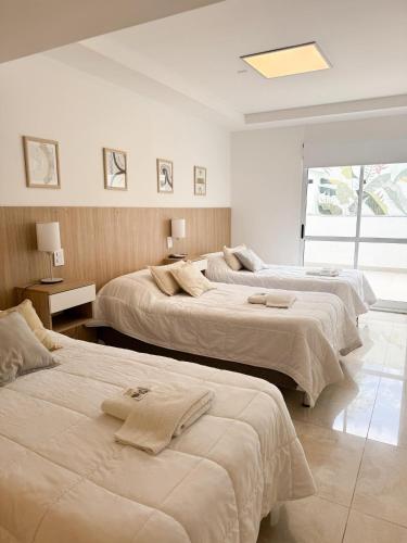 a bedroom with three beds with towels on them at Casa espectacular con 3 habitaciones en suite de lujo, 4 baños, patio al aire libre con jacuzzi y ubicacion perfecta a 3 cuadras de la plaza - Bonavista Rentals in Salta