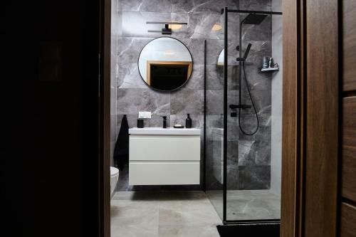 アウグストゥフにあるApartament CzarnyBlaskの洗面台と鏡のあるバスルーム