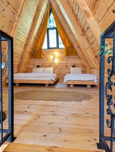 a bedroom in a log cabin with two beds at Walnut Bungalow in Çamlıhemşin