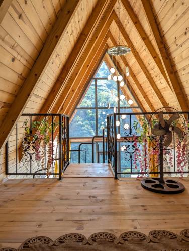 a room with a vaulted ceiling with a large window at Walnut Bungalow in Çamlıhemşin