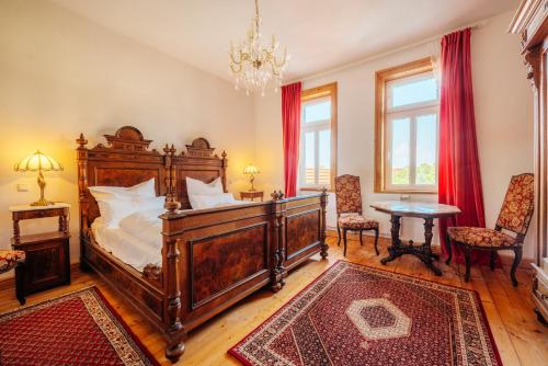 a bedroom with a large wooden bed and a table at Unik Villa- Luxus Appartemente im Oberharz in Sankt Andreasberg