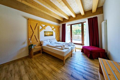 a bedroom with a bed and a large window at RTA Hotel Le Vallene in Terlago