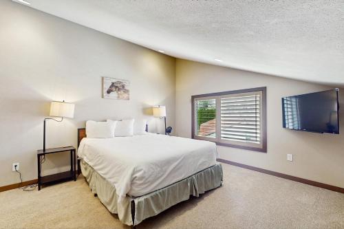 ein Schlafzimmer mit großem Bett und Flachbildfernseher in der Unterkunft Lake Chelan Shores - Beachfront Splendor 12-5 in Lakeside