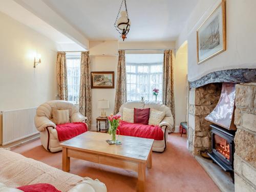 ein Wohnzimmer mit Sofas und Kamin in der Unterkunft Harvey Cottage in Colyton
