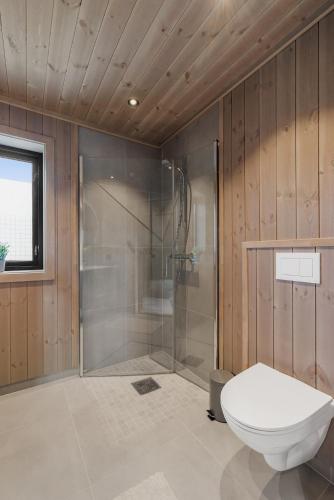 a bathroom with a shower and a toilet in it at Sentralt plassert hytte, alt i gangavstand in Flå