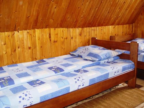 a bedroom with a bed with a wooden wall at Guesthouse Durmitor Magic in Žabljak