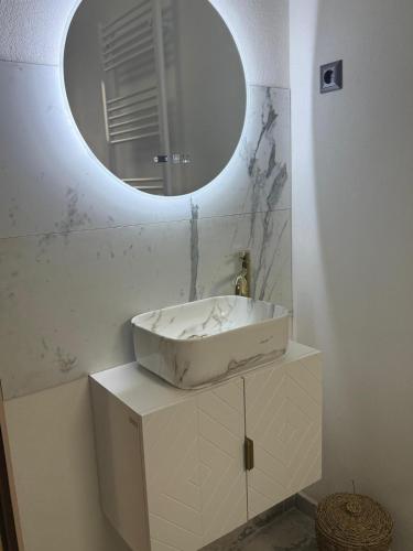 a bathroom with a white sink and a mirror at Cabana MBM in Baia-Sprie