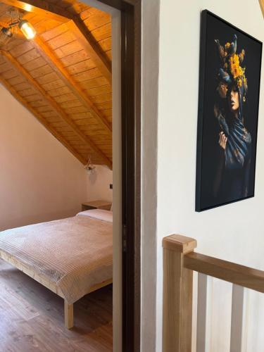 a bedroom with a bed and a painting on the wall at Cabana MBM in Baia-Sprie