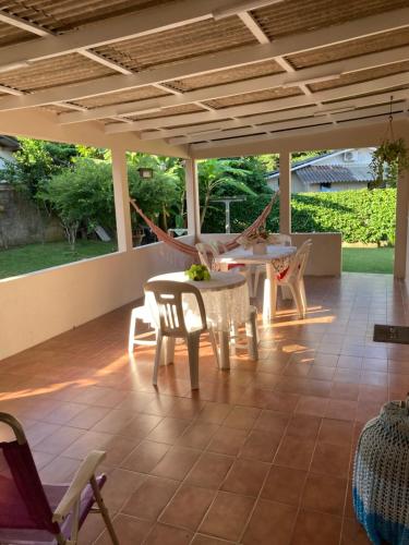 eine Terrasse mit einem Tisch, Stühlen und einer Hängematte in der Unterkunft Casa 183 in Itajaí