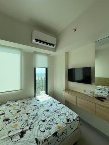 a bedroom with a bed and a flat screen tv at Osaka riverview Apartment PIK 2 by SS in Rawalumpang