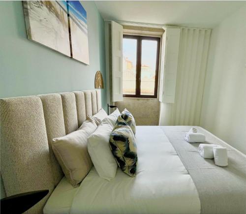 a bedroom with a large white bed with pillows at Water Vibes Porto by MyMoradia in Porto