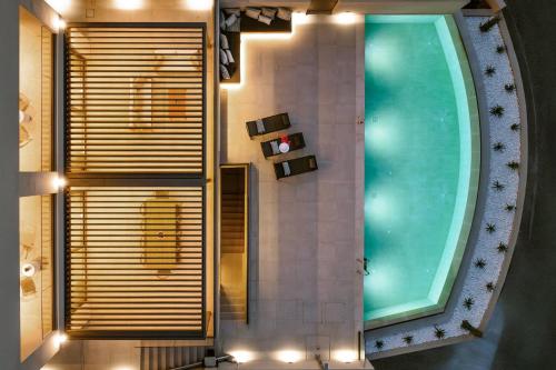 a bathroom with a swimming pool and a large window at Majo Luxury Villas Panoramic Sea View Retreat with Heated Private Pools & Gym & Sauna in Agia Pelagia