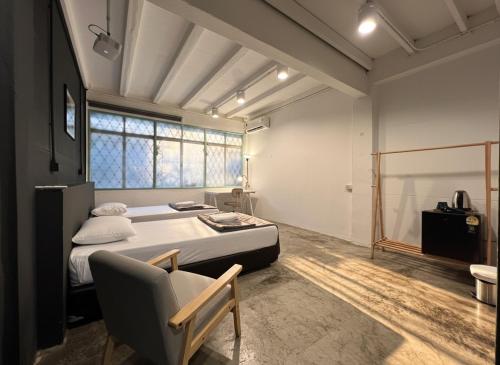 a bedroom with a large bed and a chair at Chatel Samyan - Self check-in in Bang Rak