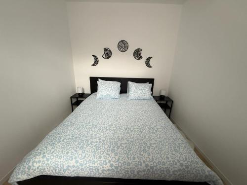 a bedroom with a bed with a comforter and two pillows at Bright apartment in the heart of Chimay, 40 m² with view in Chimay