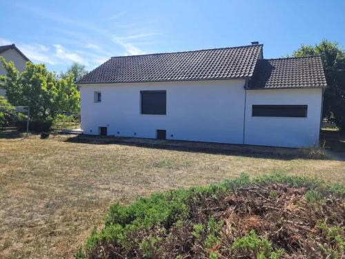a white house with two windows on a yard at Maison cosy à Meaulne-Vitray avec jardin in Meaulne