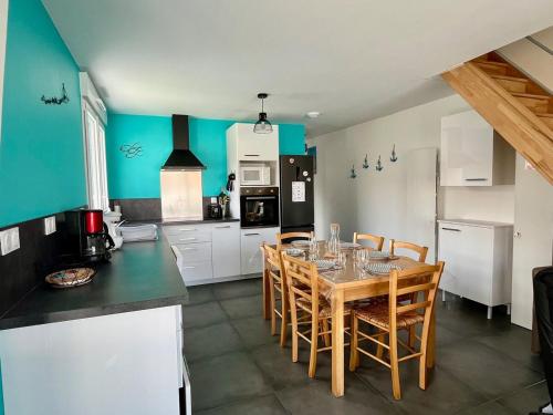 Una cocina con una mesa y sillas en una habitación. en Ti'Belot - calme près de la mer, en LʼAiguillon-sur-Mer