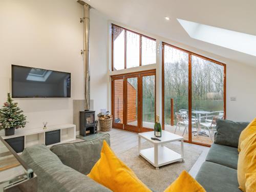 Una sala de estar con un sofá y un televisor. en Waterside Lodge Four - Uk36706, en Southowram