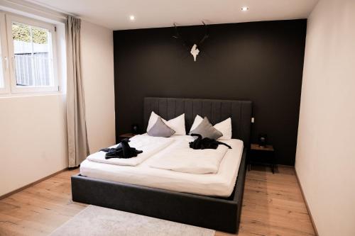 a bedroom with a large bed with black walls at HOLARI Appartement in Reith bei Seefeld